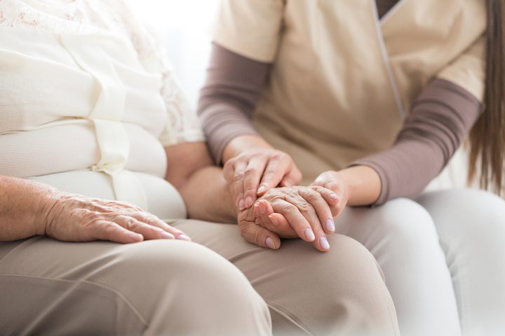 nurse massaging the hand of an elderly person