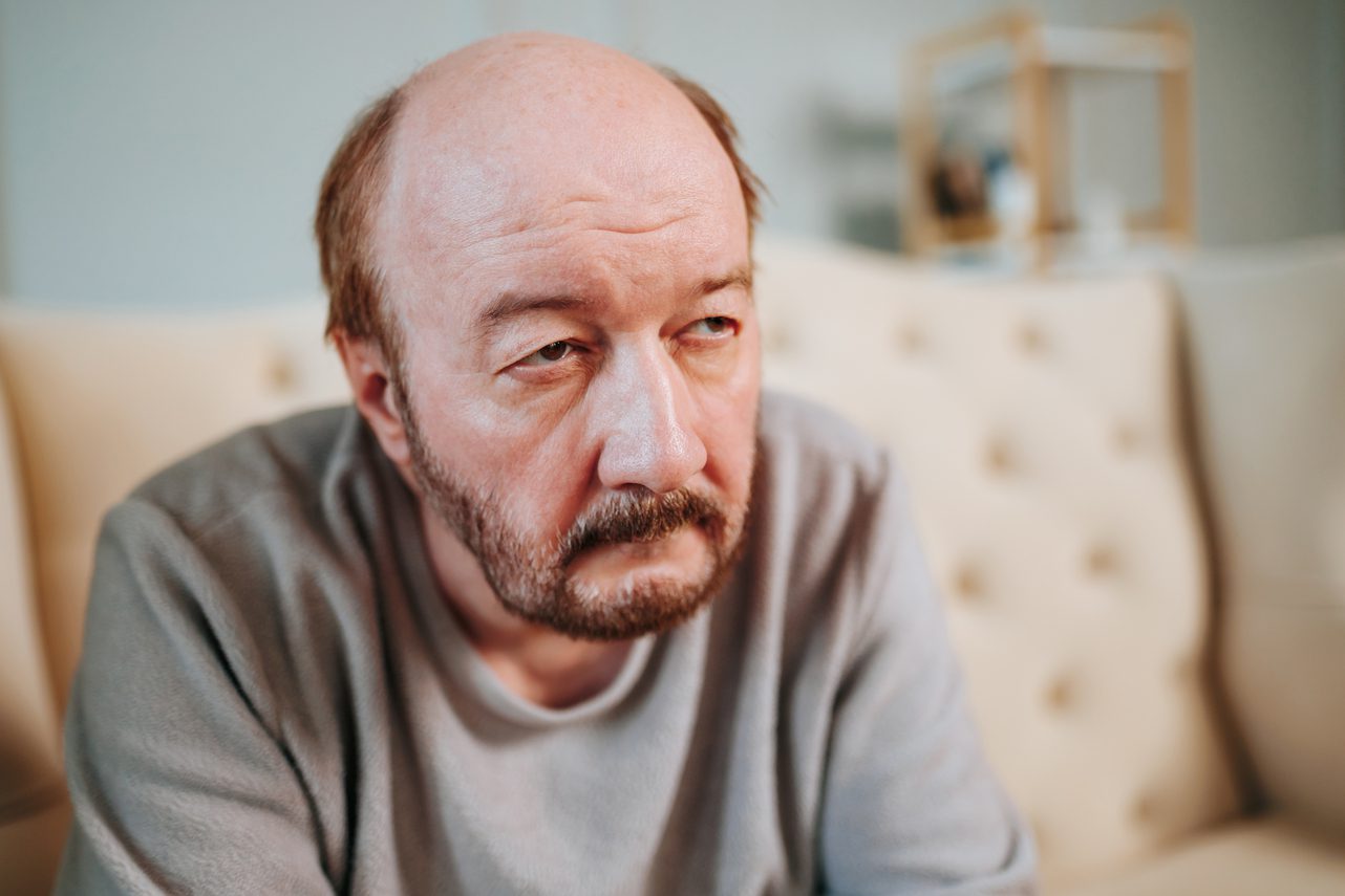 man feeling frustrated on a couch