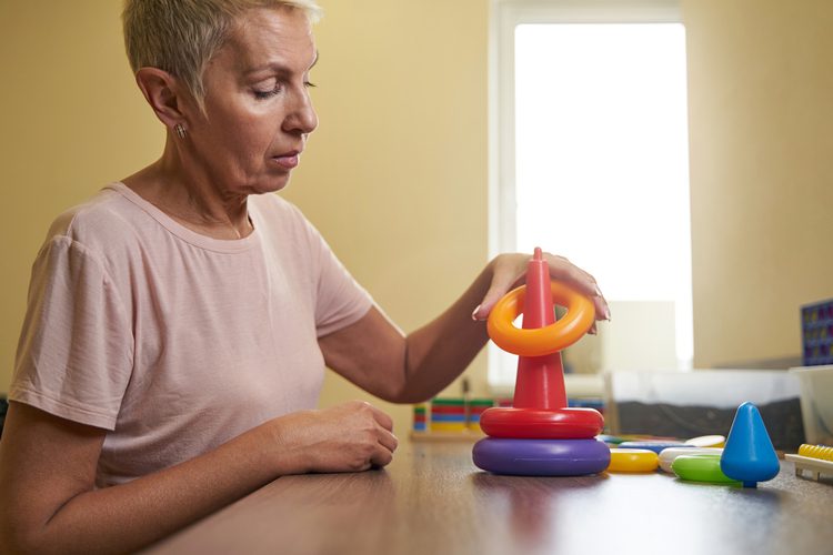 Photo of ergotherapy with stroke woman in rehab center